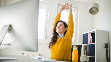 
		Woman stretching at her desk
	